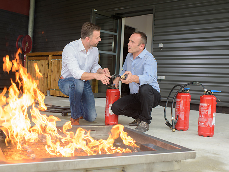 Fire Safety Expert instructing on correct use of fire extinguisher