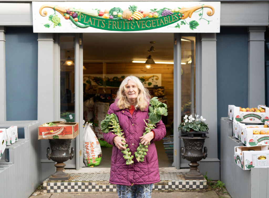 Woman standing in front of greengrocer's shop